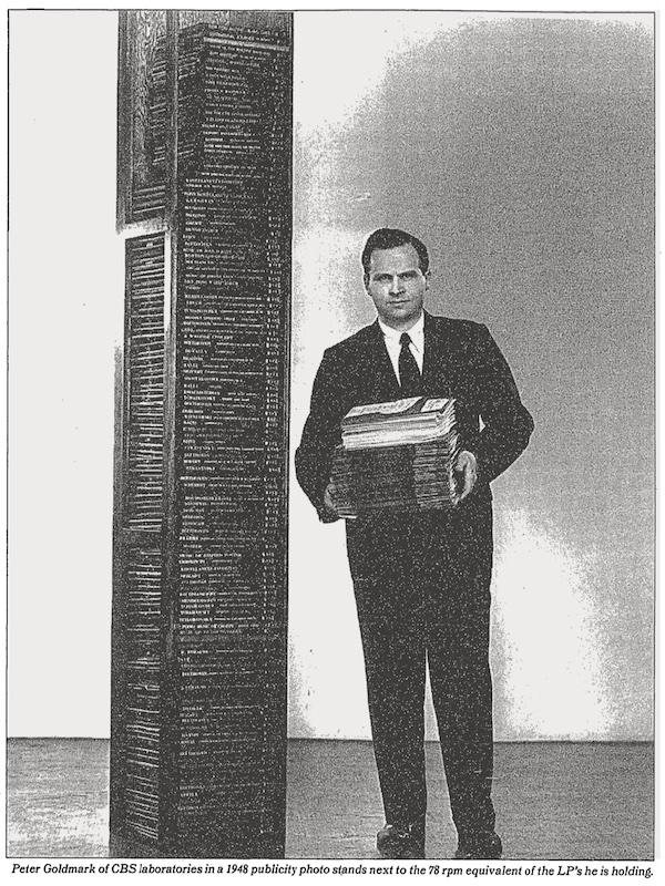 Peter Goldmark of CBS laboratories in a 1948 publicity photo stands next to the 78 rpm equivalent of the LP's he is holding.