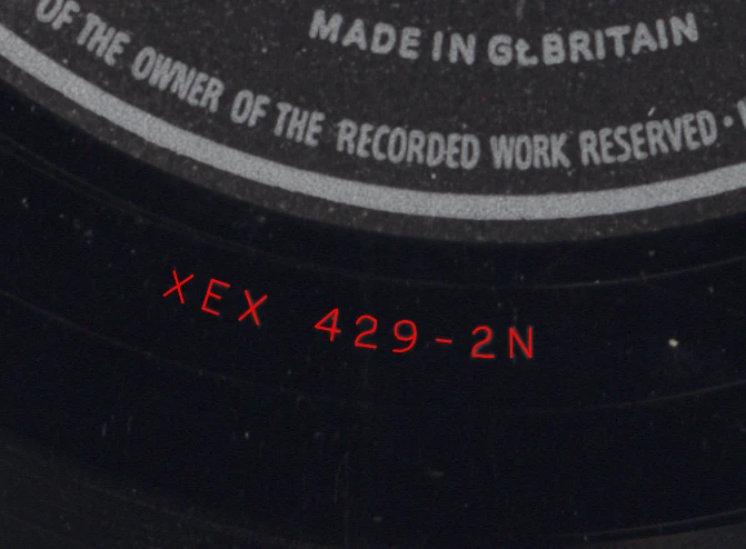 The run-out area and part of the label on side 1 of my copy of Parlophone PMC 1203 (Pepe Jaramillo, Mexican Pizza). The stamping is XEX 429-2N. I traced the stamping in red